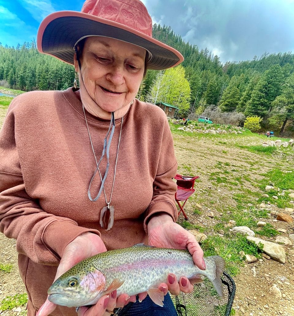 Fly fishing guide holding a rainbow trout on a guided trip near Pagosa Springs