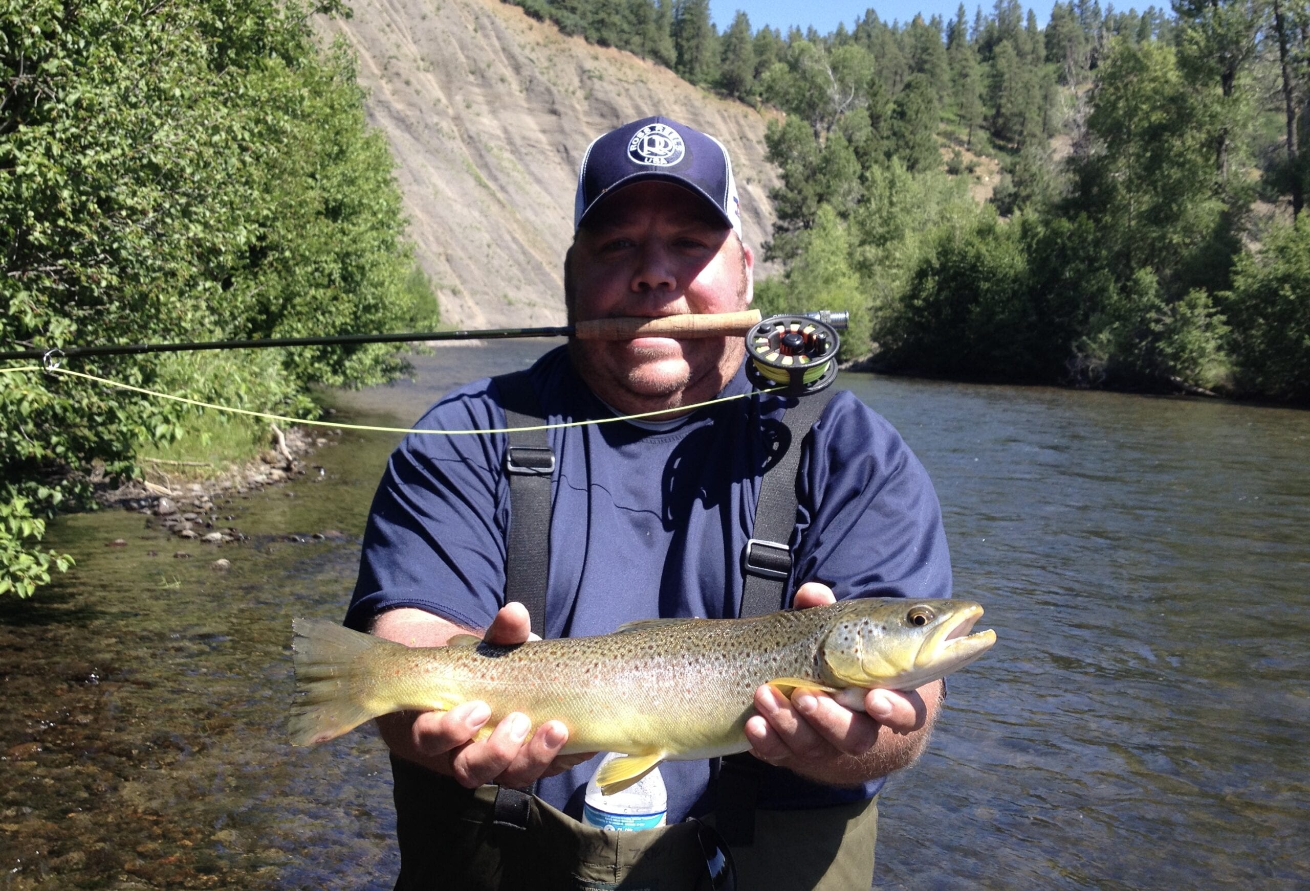 Angler holding trophy brown trout wading the San Juan River, guided fly fishing, Pagosa Springs