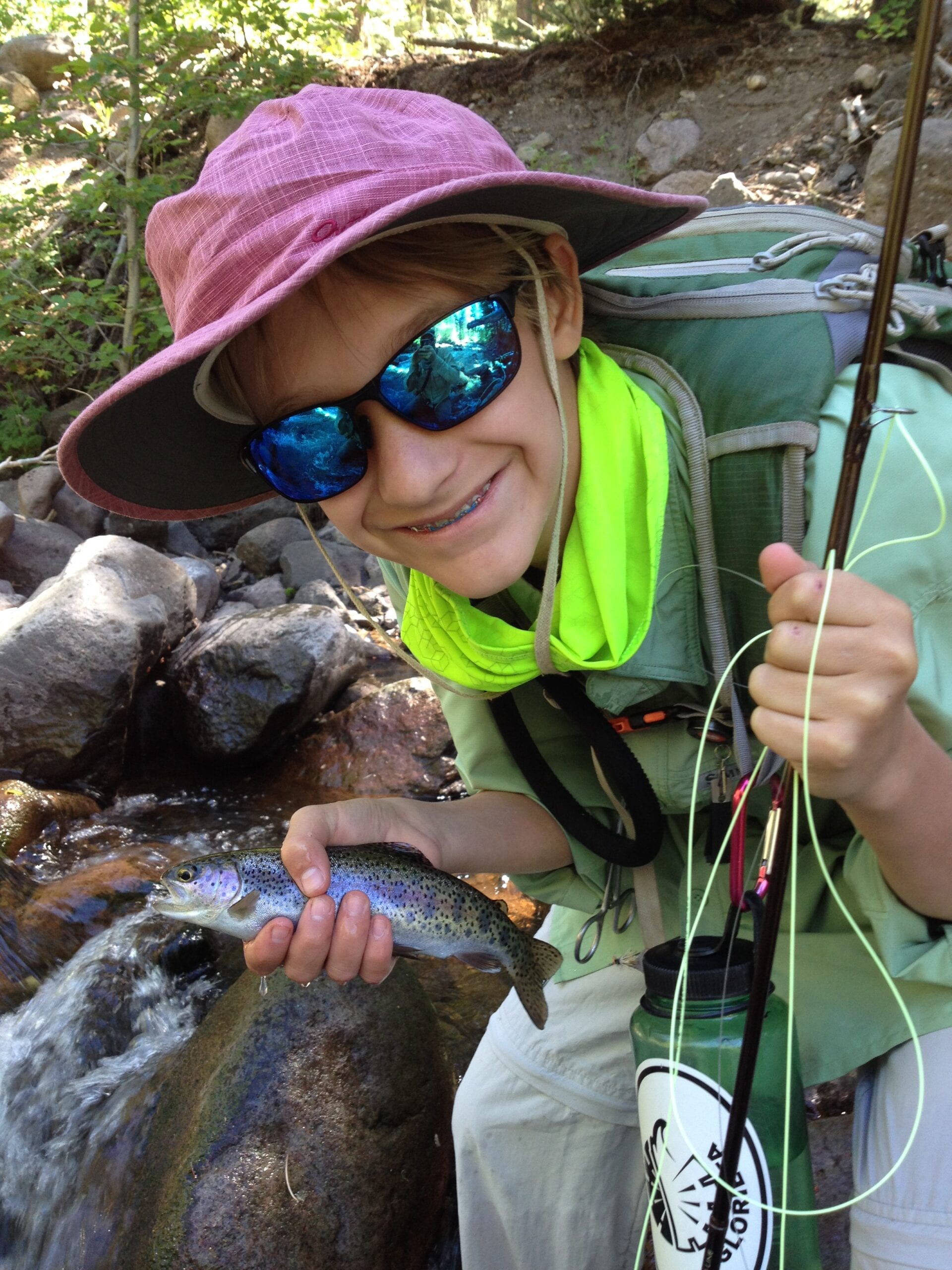 Young angler holding a trout on a rocky high-alpine creek in the San Juan National Forest