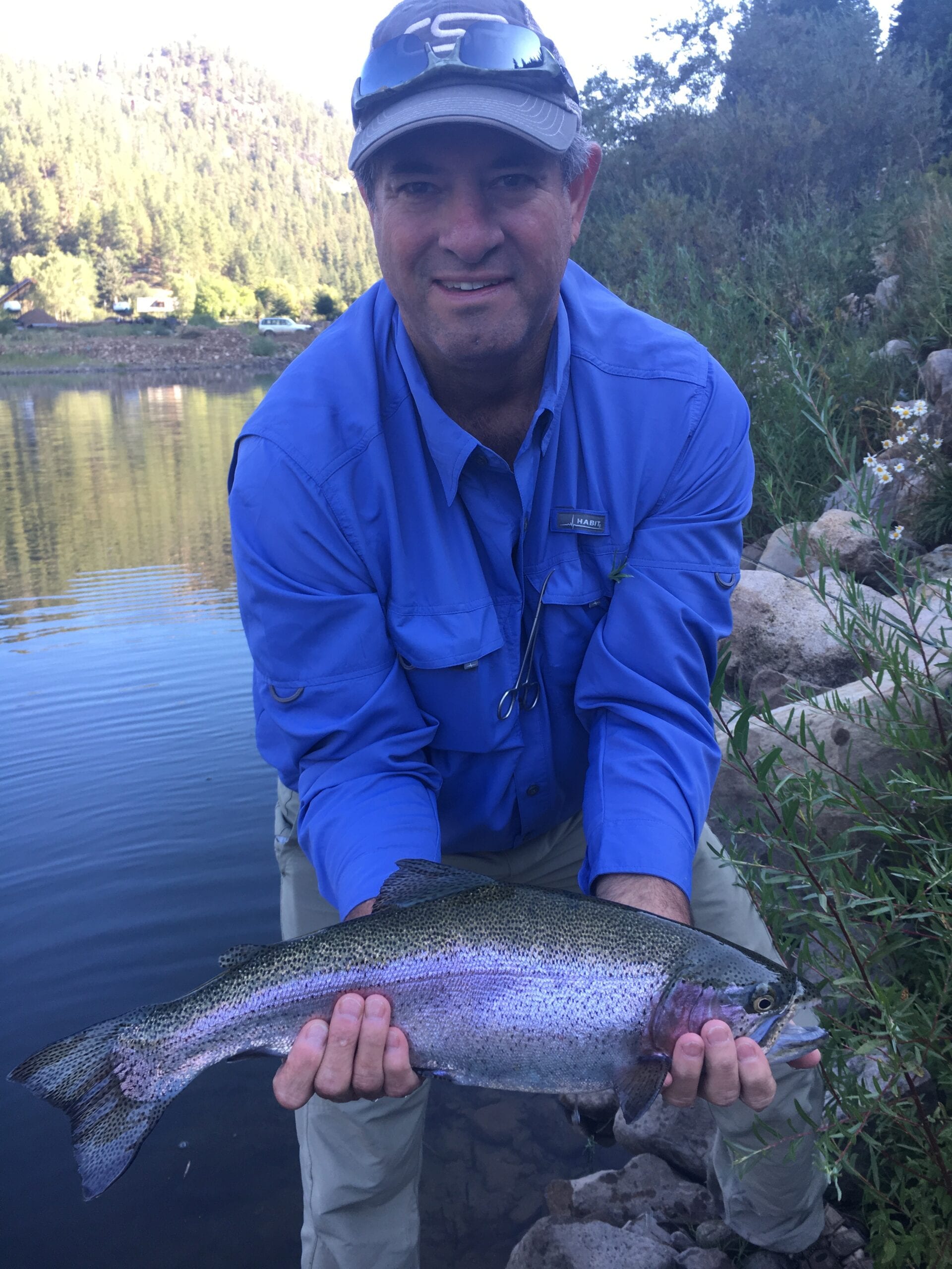 Angler holding trophy rainbow trout at Snow Angel Ranch private fly fishing, Pagosa Springs