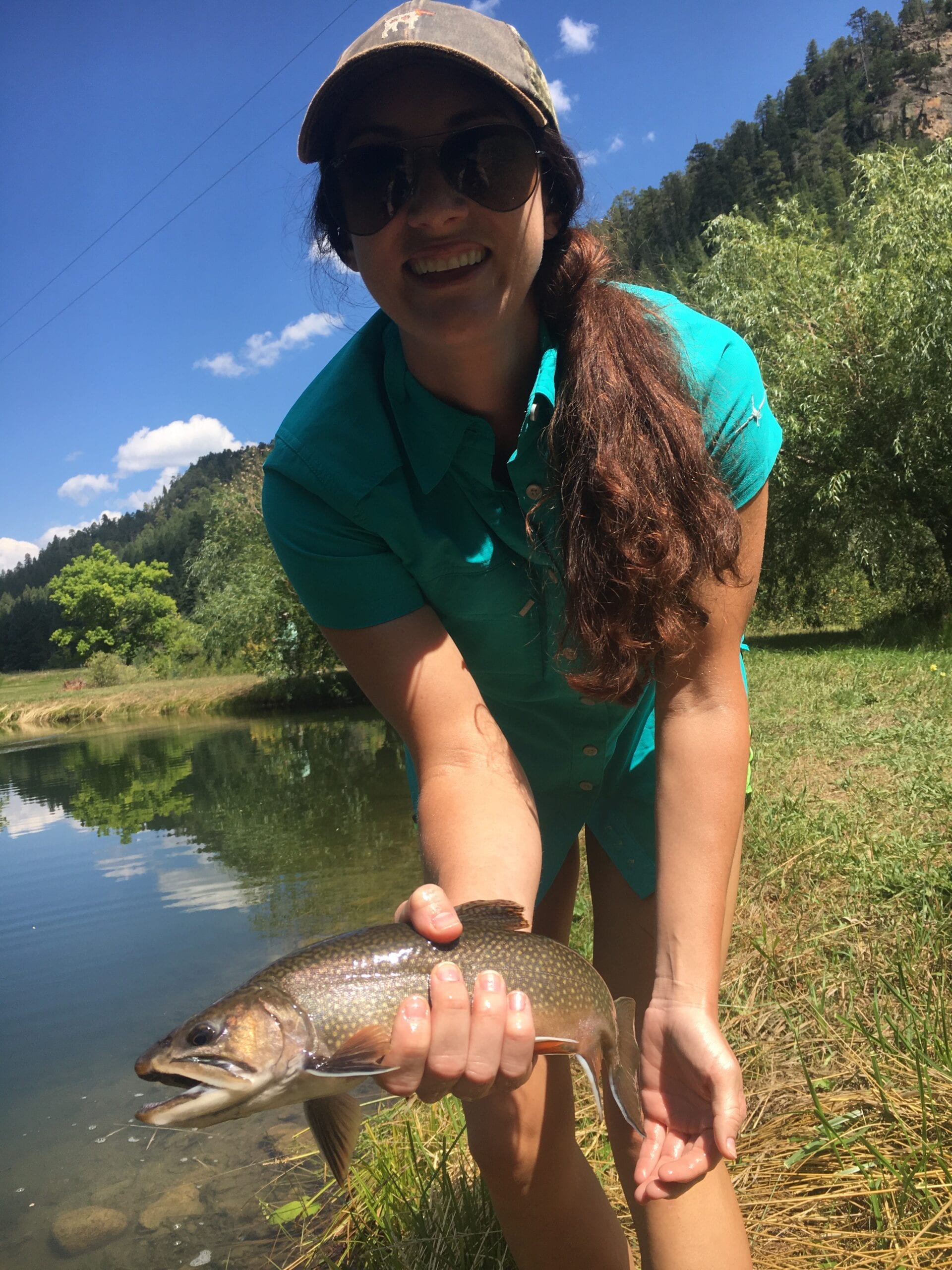 Woman angler with brook trout at Snow Angel Ranch private fly fishing, Pagosa Springs, Colorado