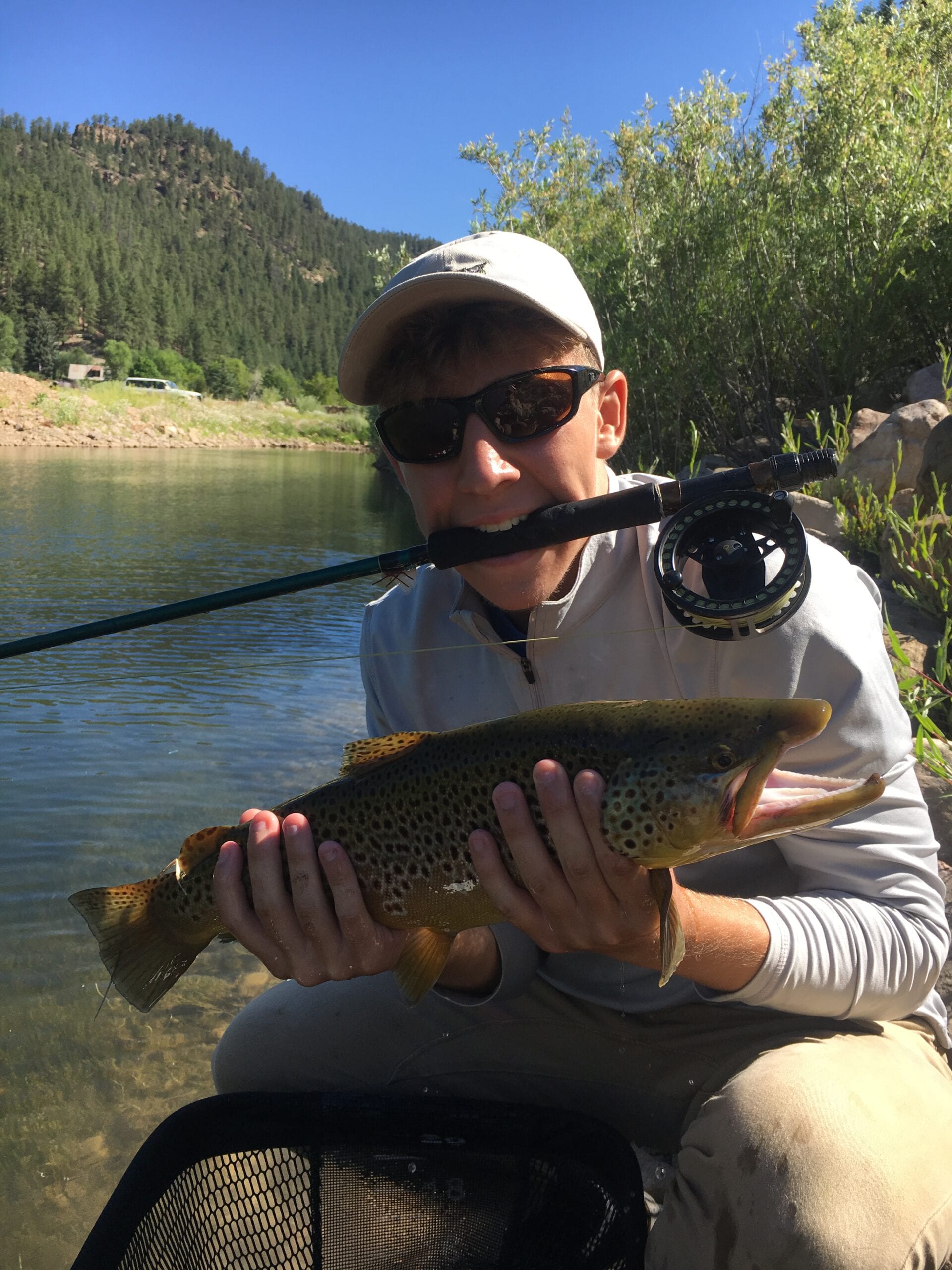 Angler holding trophy brown trout on guided fly fishing trip San Juan River Pagosa Springs Colorado